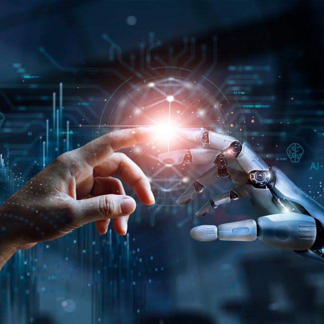 Human hand and robot hand touching, creating a light source. 